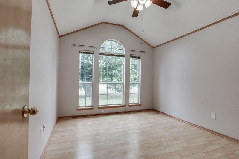 2708 NW 161st Street, Edmond, OK 73013 unfurnished room with crown molding, light hardwood / wood-style flooring, ceiling fan, and vaulted ceiling