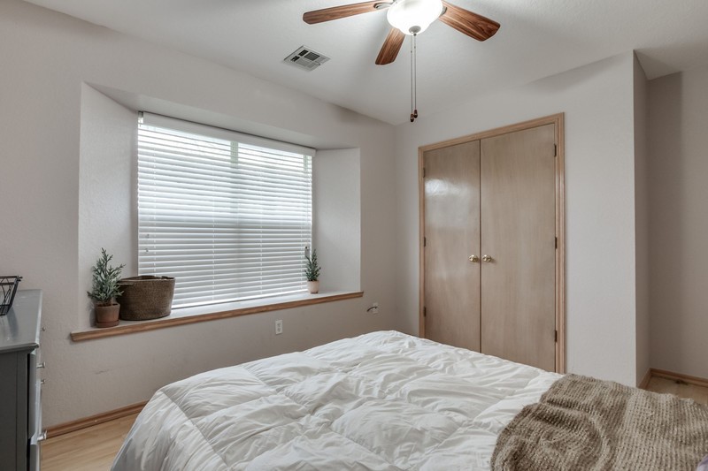 2708 NW 161st Street, Edmond, OK 73013 bedroom with light hardwood / wood-style floors, ceiling fan, and a closet