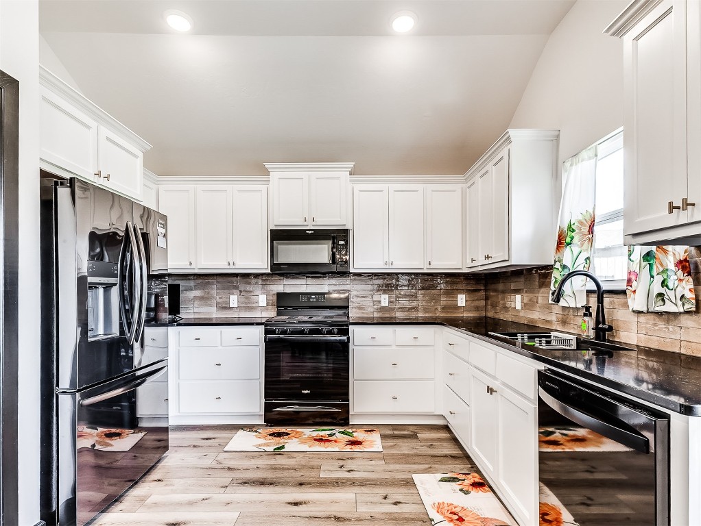 12613 NW 4th Terrace, Yukon, OK 73099 kitchen featuring black appliances, tasteful backsplash, white cabinets, sink, and light wood-type flooring