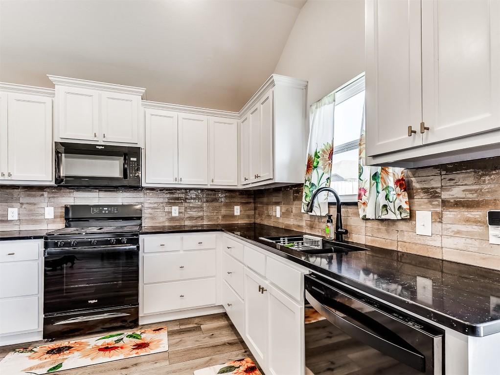 12613 NW 4th Terrace, Yukon, OK 73099 kitchen with white cabinets, sink, tasteful backsplash, black appliances, and light hardwood / wood-style flooring
