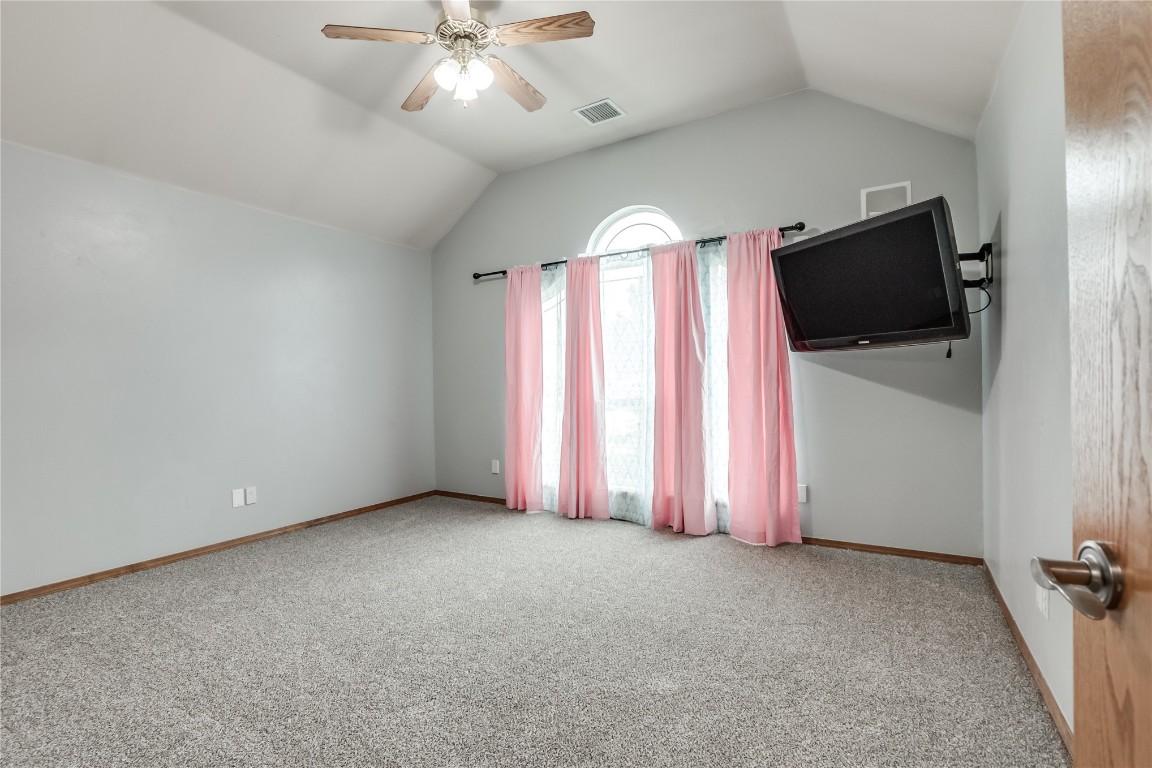9212 SW 26th Street, Oklahoma City, OK 73128 carpeted empty room featuring lofted ceiling and ceiling fan