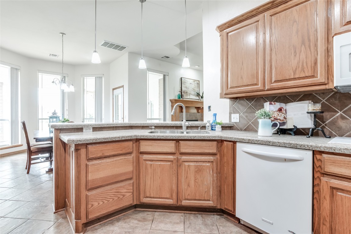 9212 SW 26th Street, Oklahoma City, OK 73128 kitchen featuring sink, light tile flooring, backsplash, pendant lighting, and white dishwasher