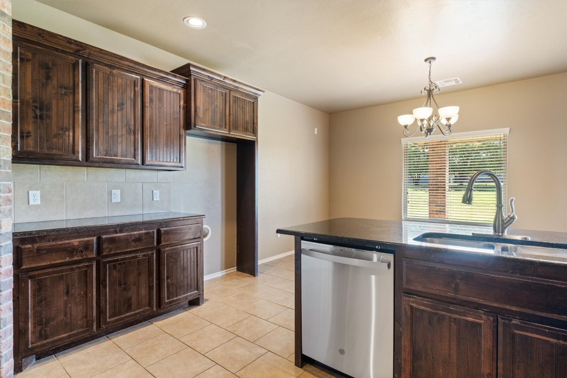14708 Almond Valley Drive, Oklahoma City, OK 73165 kitchen featuring light tile flooring, sink, tasteful backsplash, dishwasher, and dark brown cabinetry