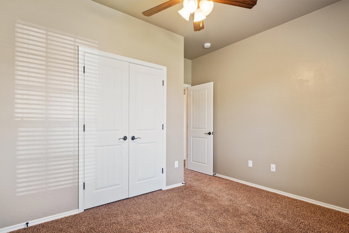 14708 Almond Valley Drive, Oklahoma City, OK 73165 unfurnished bedroom with a closet, ceiling fan, and carpet