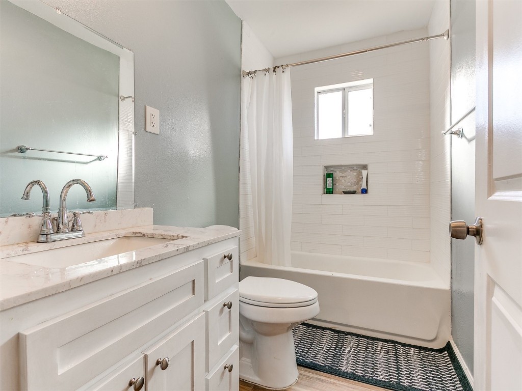 2830 W Georgia Avenue, Chickasha, OK 73018 full bathroom with shower / bath combo, wood-type flooring, toilet, and vanity