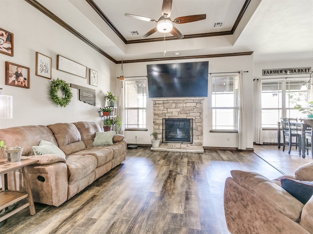 2409 Wayne Cutt Avenue, Yukon, OK 73099 living room featuring a healthy amount of sunlight, a fireplace, a raised ceiling, and hardwood / wood-style flooring