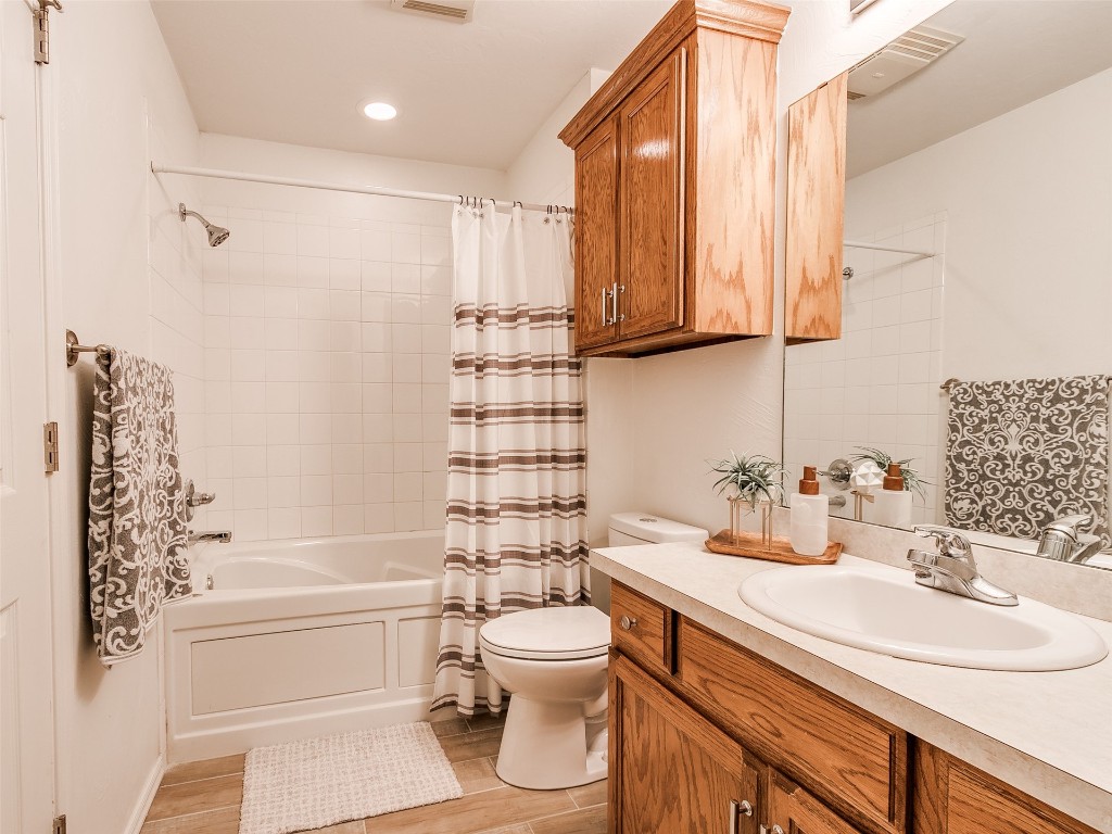 1473 N 1st Street, Harrah, OK 73045 full bathroom featuring toilet, shower / bath combination with curtain, and vanity