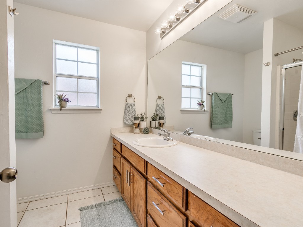 1473 N 1st Street, Harrah, OK 73045 bathroom featuring vanity with extensive cabinet space, toilet, and tile floors