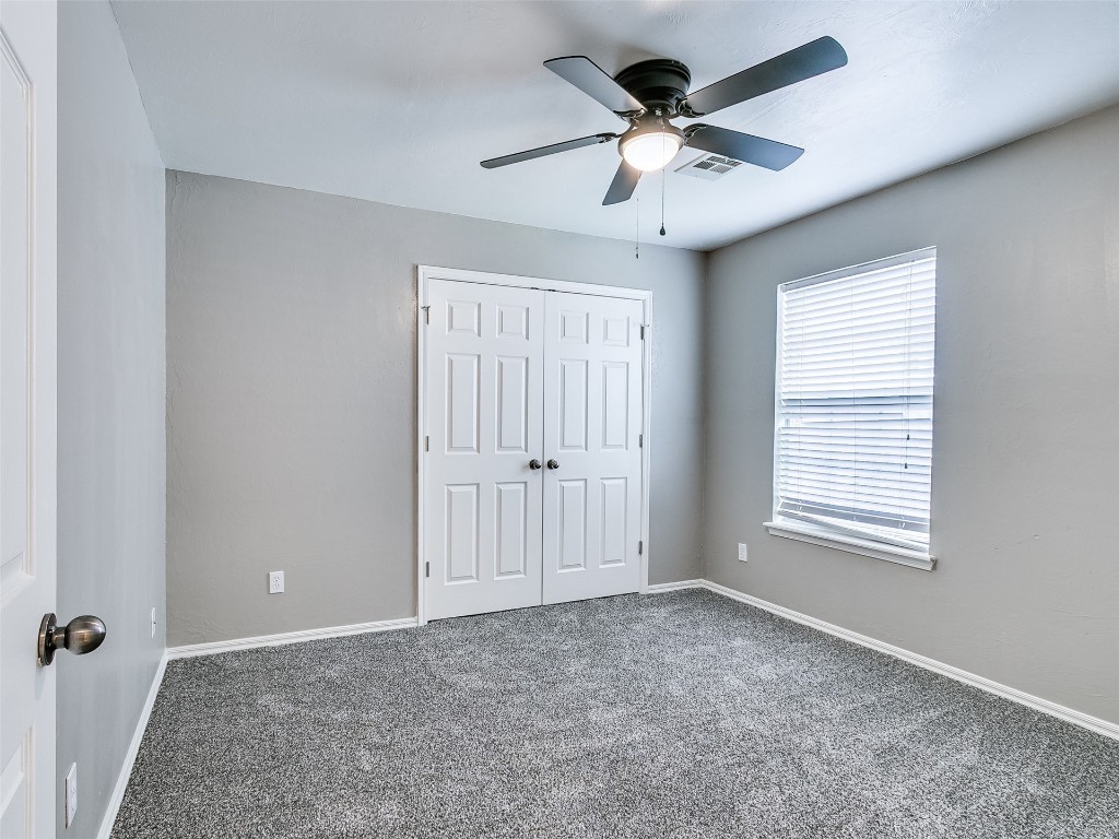 1473 N 1st Street, Harrah, OK 73045 unfurnished bedroom featuring a closet, ceiling fan, and carpet flooring