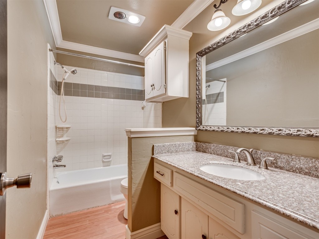 1413 Danbury Place, Oklahoma City, OK 73099 full bathroom with hardwood / wood-style floors, toilet, tiled shower / bath, and ornamental molding