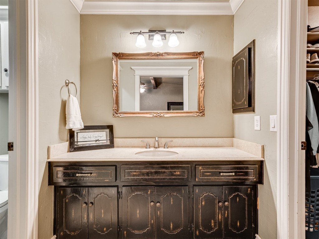 1413 Danbury Place, Oklahoma City, OK 73099 bathroom with vanity, toilet, and ornamental molding