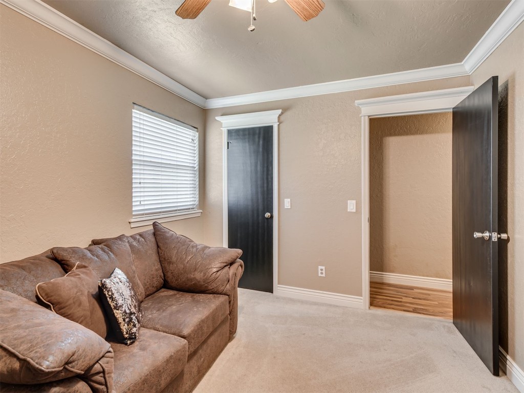 1413 Danbury Place, Oklahoma City, OK 73099 living room with carpet floors, ceiling fan, and ornamental molding
