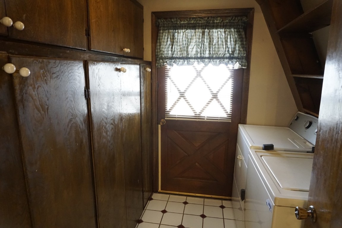 25550 County Road 110, Perry, OK 73077 washroom with washer and clothes dryer, cabinets, and light tile floors