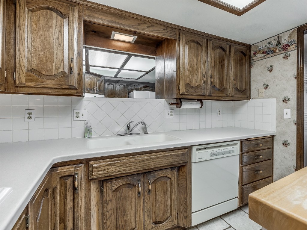 9610 Warringer Court, Oklahoma City, OK 73162 kitchen featuring sink, tasteful backsplash, dishwasher, and light tile floors