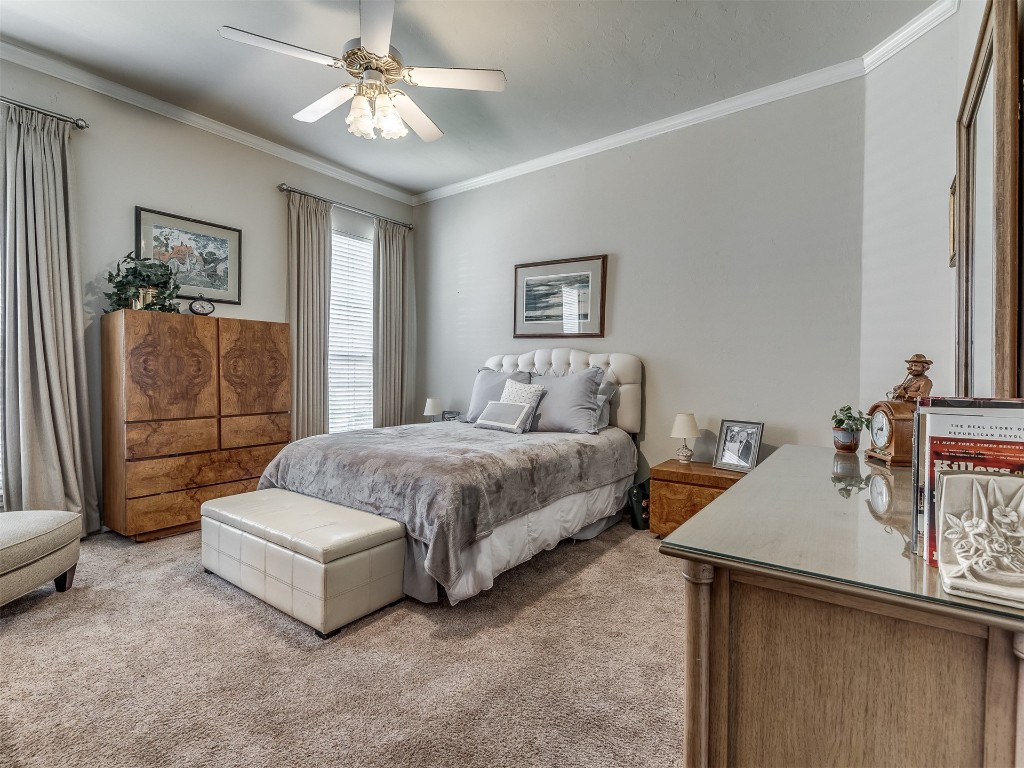15608 Traditions Boulevard, Edmond, OK 73013 carpeted bedroom featuring ceiling fan and crown molding