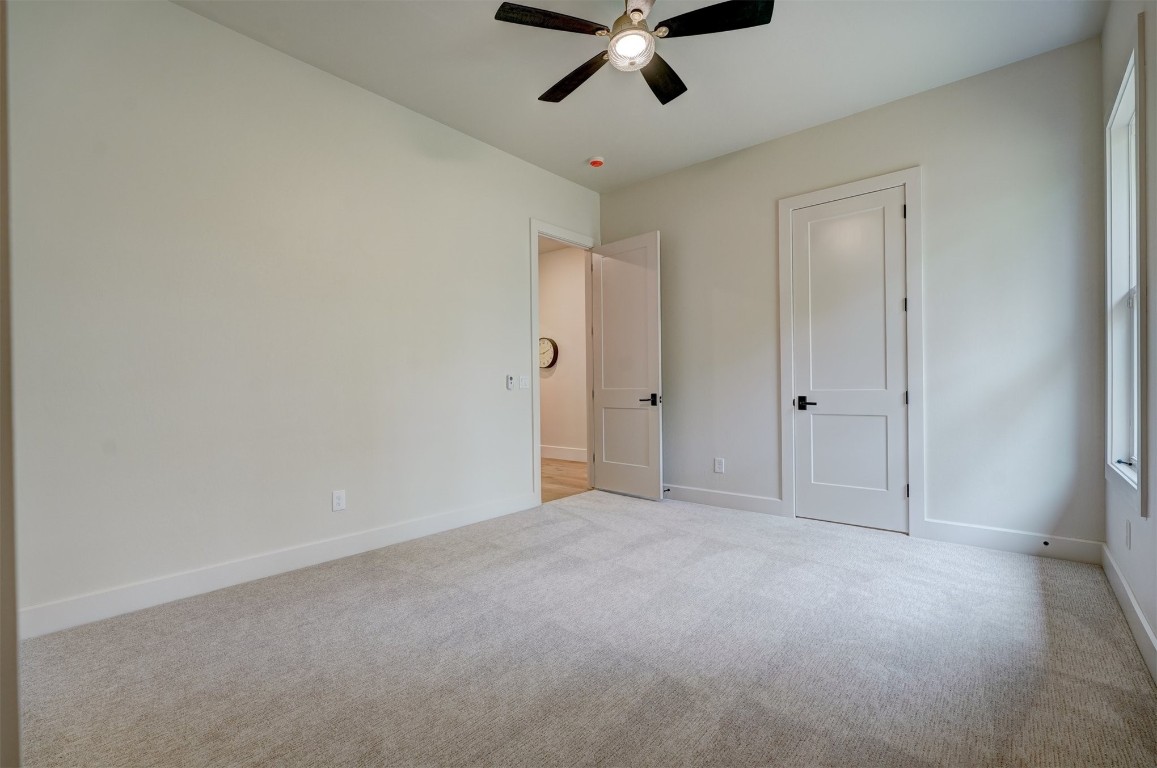6309 Canopy Lane, Edmond, OK 73025 unfurnished bedroom with light colored carpet and ceiling fan