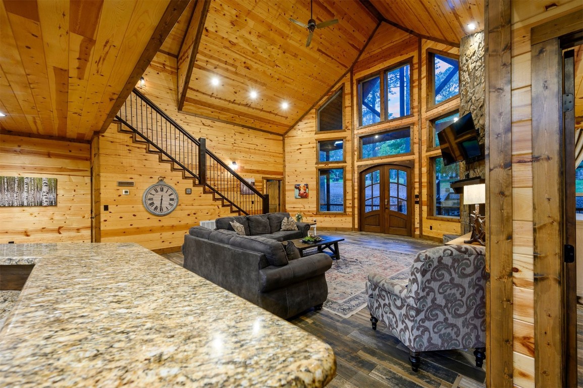 335 Mountain Pine Trail, Broken Bow, OK 74728 living room with wooden walls, high vaulted ceiling, hardwood / wood-style flooring, beam ceiling, and wood ceiling