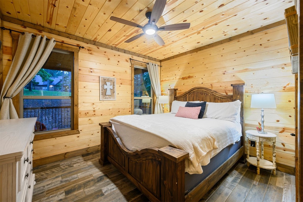 335 Mountain Pine Trail, Broken Bow, OK 74728 bedroom featuring wood ceiling, wood walls, ceiling fan, and dark hardwood / wood-style floors