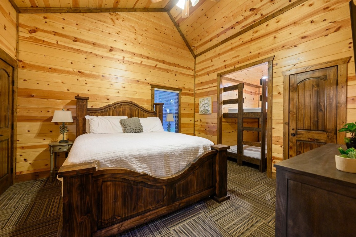 335 Mountain Pine Trail, Broken Bow, OK 74728 bedroom with high vaulted ceiling, dark carpet, and wood ceiling