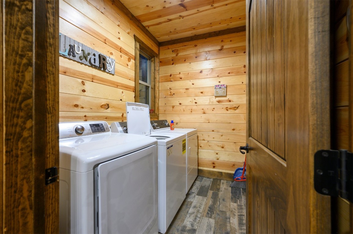 335 Mountain Pine Trail, Broken Bow, OK 74728 clothes washing area featuring wood ceiling, washing machine and dryer, dark hardwood / wood-style floors, and wood walls