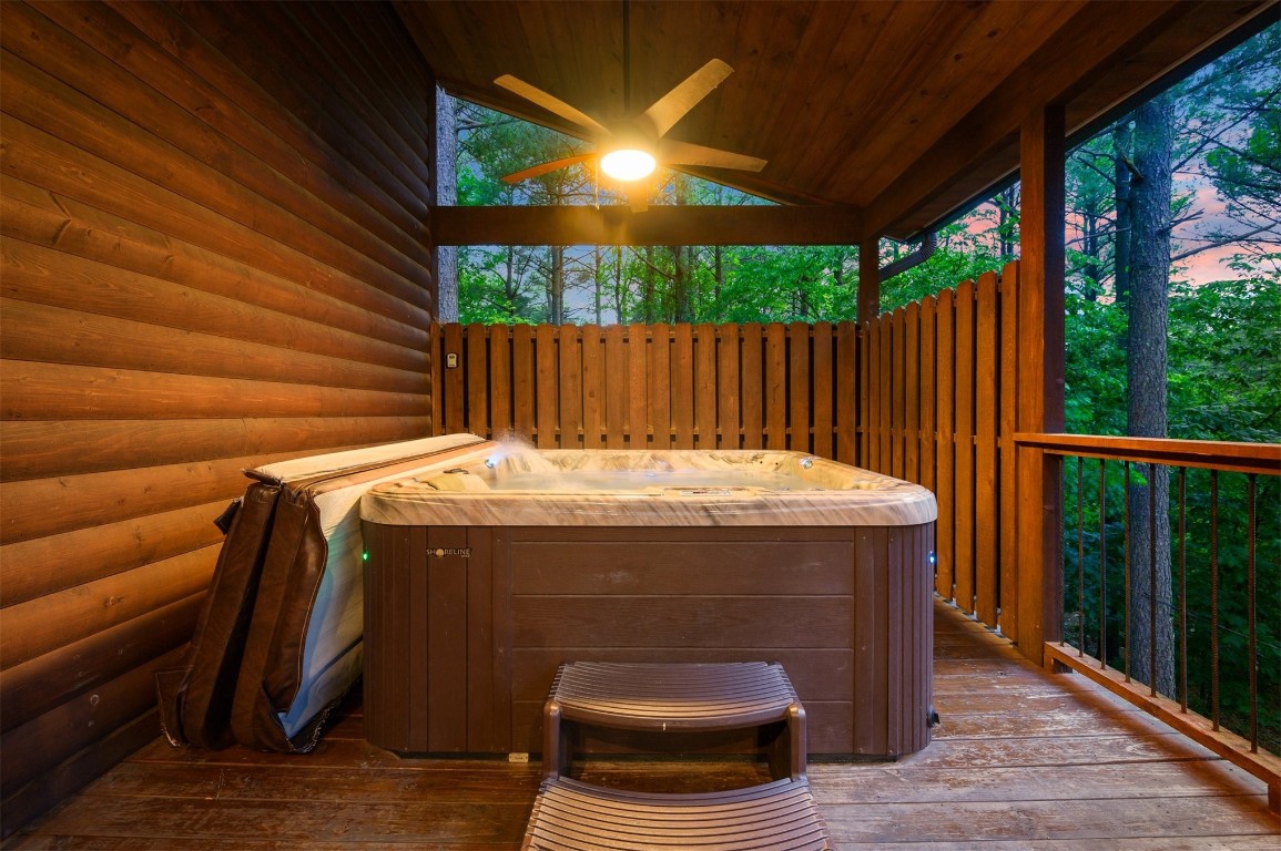 335 Mountain Pine Trail, Broken Bow, OK 74728 deck at dusk featuring a hot tub and ceiling fan