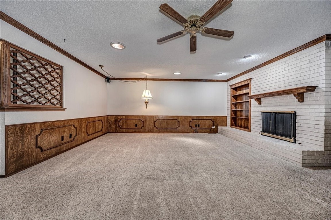 923 Rosebrier Court, Guthrie, OK 73044 carpeted spare room with a textured ceiling, ceiling fan, and crown molding