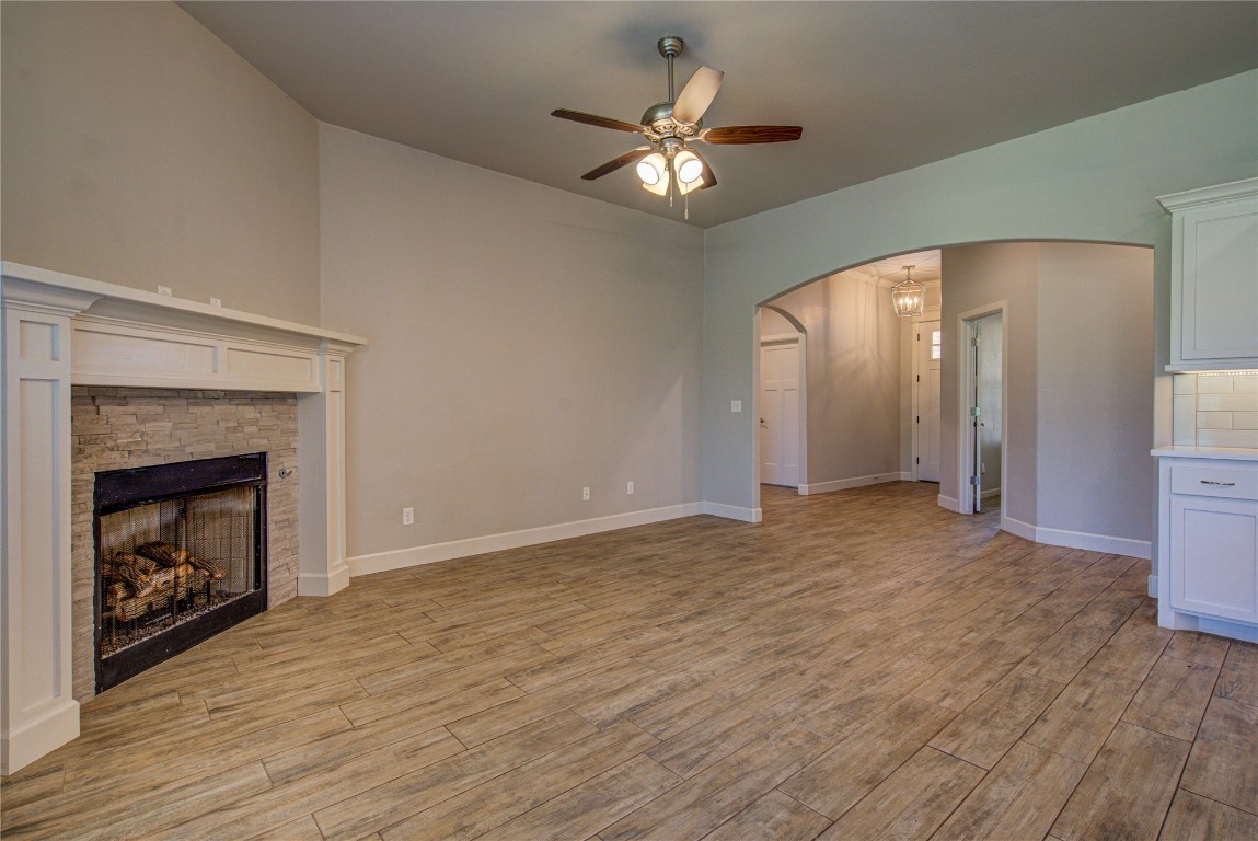 201 Casey Lane, Washington, OK 73093 unfurnished living room featuring light hardwood / wood-style flooring, ceiling fan, and a stone fireplace