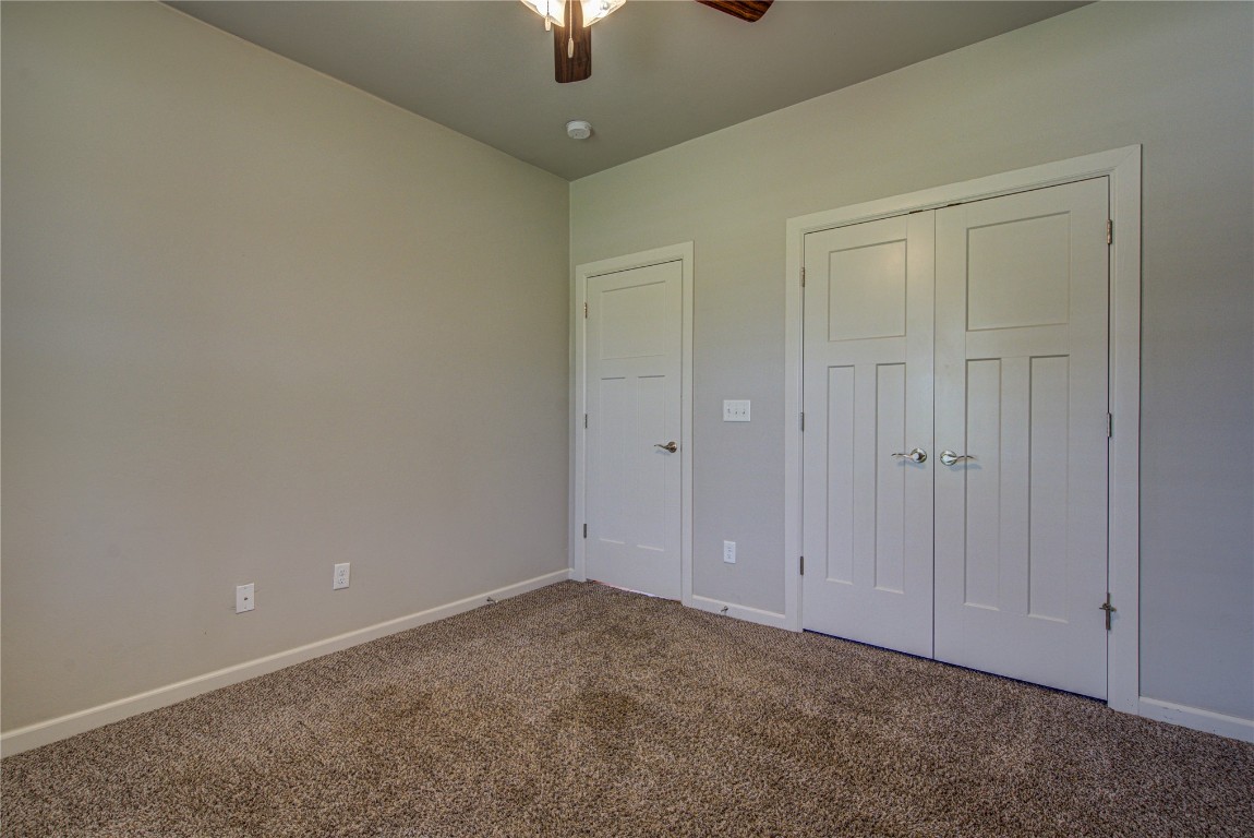 201 Casey Lane, Washington, OK 73093 unfurnished bedroom featuring a closet, ceiling fan, and carpet flooring
