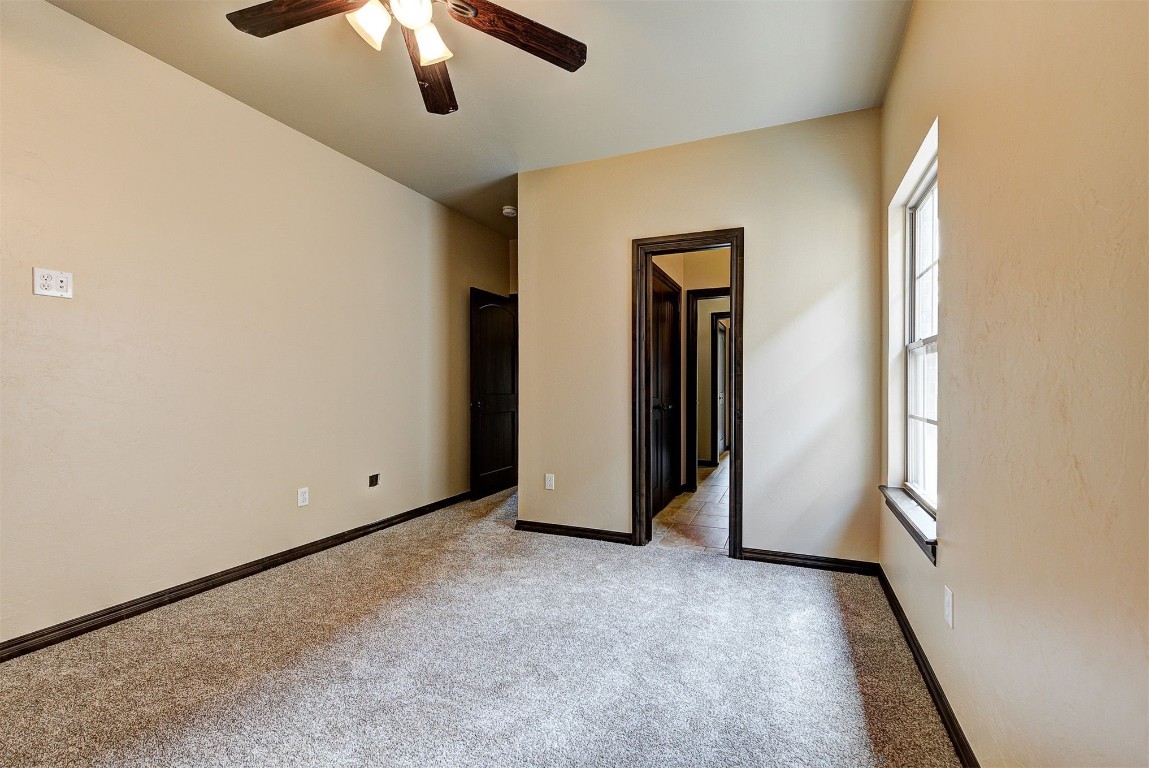 1713 Rain Tree Lane, Choctaw, OK 73020 unfurnished bedroom featuring ceiling fan and light carpet