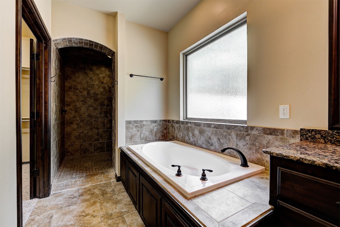 1713 Rain Tree Lane, Choctaw, OK 73020 bathroom featuring tile flooring and a bath to relax in