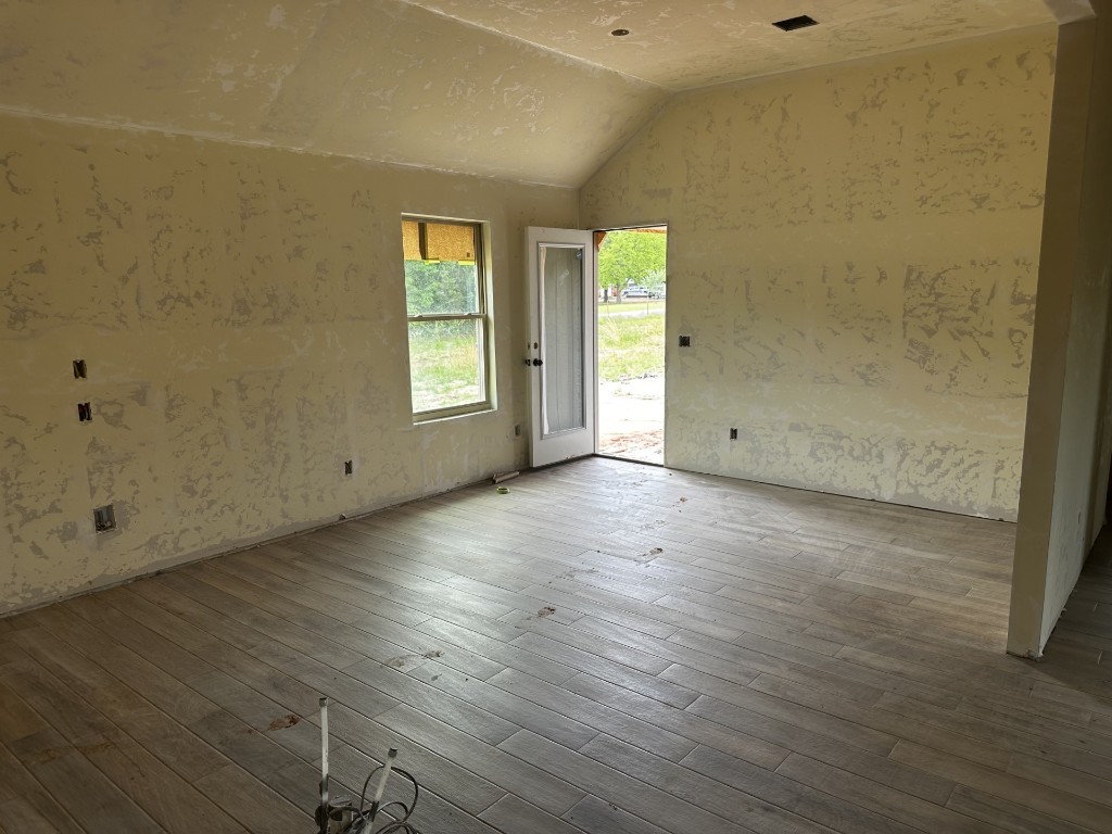 121 Trimble Drive, Shawnee, OK 74804 unfurnished room with wood-type flooring and vaulted ceiling