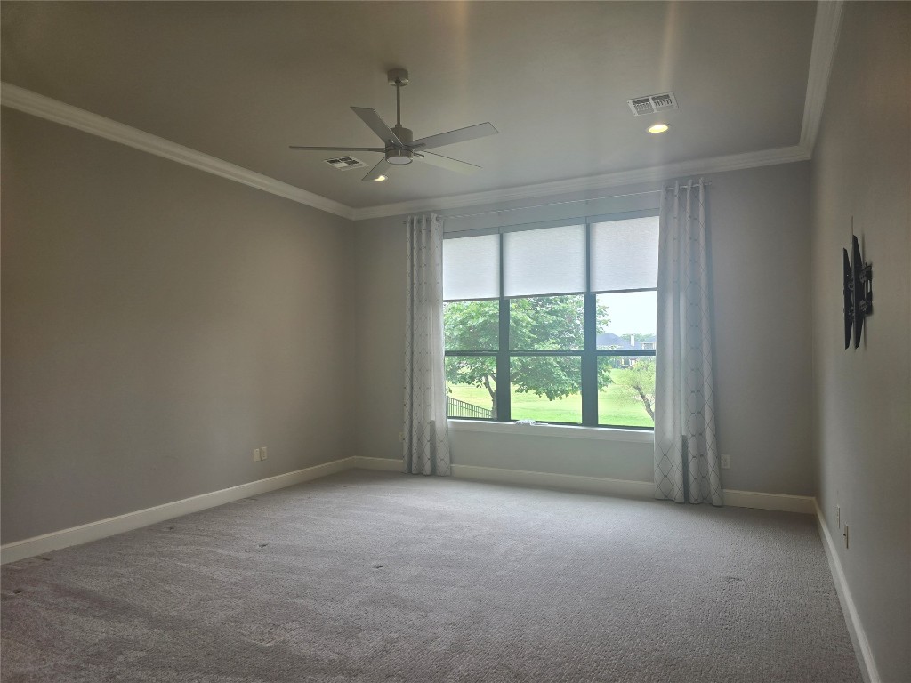 16756 Little Leaf Lane, Edmond, OK 73012 carpeted empty room featuring ceiling fan and ornamental molding