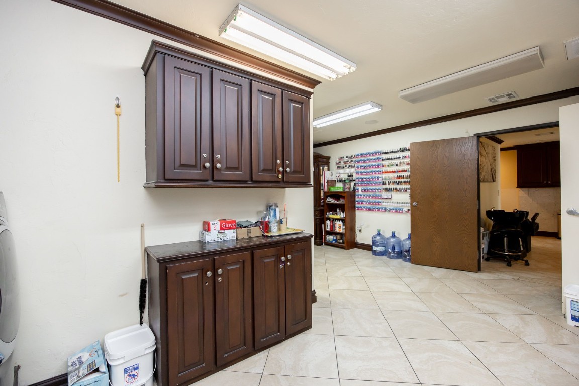 313 E 33rd Street, Edmond, OK 73013 kitchen with ornamental molding, dark brown cabinets, and light tile floors