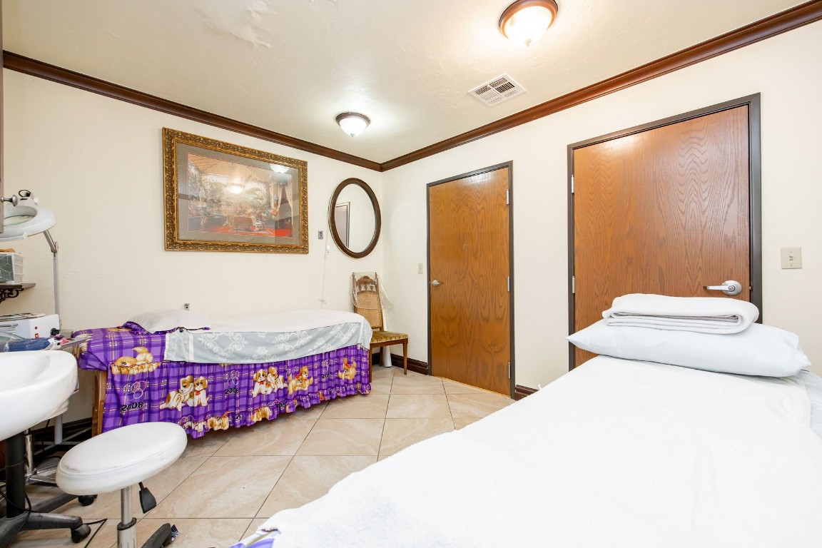 313 E 33rd Street, Edmond, OK 73013 tiled bedroom featuring ornamental molding