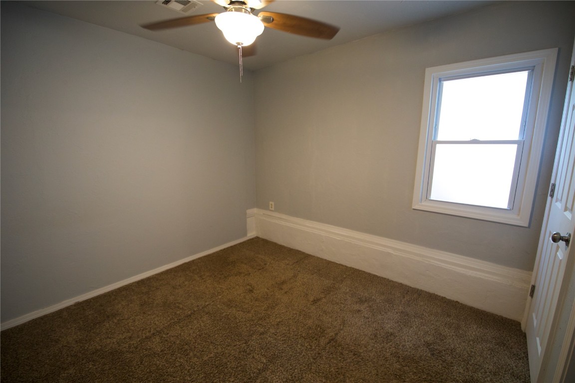 1402 N Broad Street, Guthrie, OK 73044 spare room featuring a wealth of natural light, carpet, and ceiling fan