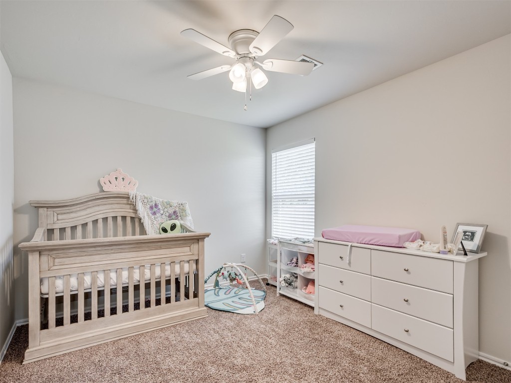 10009 Wessex Drive, Yukon, OK 73099 carpeted bedroom featuring ceiling fan and a crib