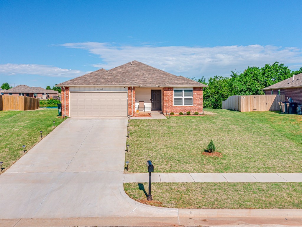 10009 Wessex Drive, Yukon, OK 73099 ranch-style house featuring a garage and a front yard