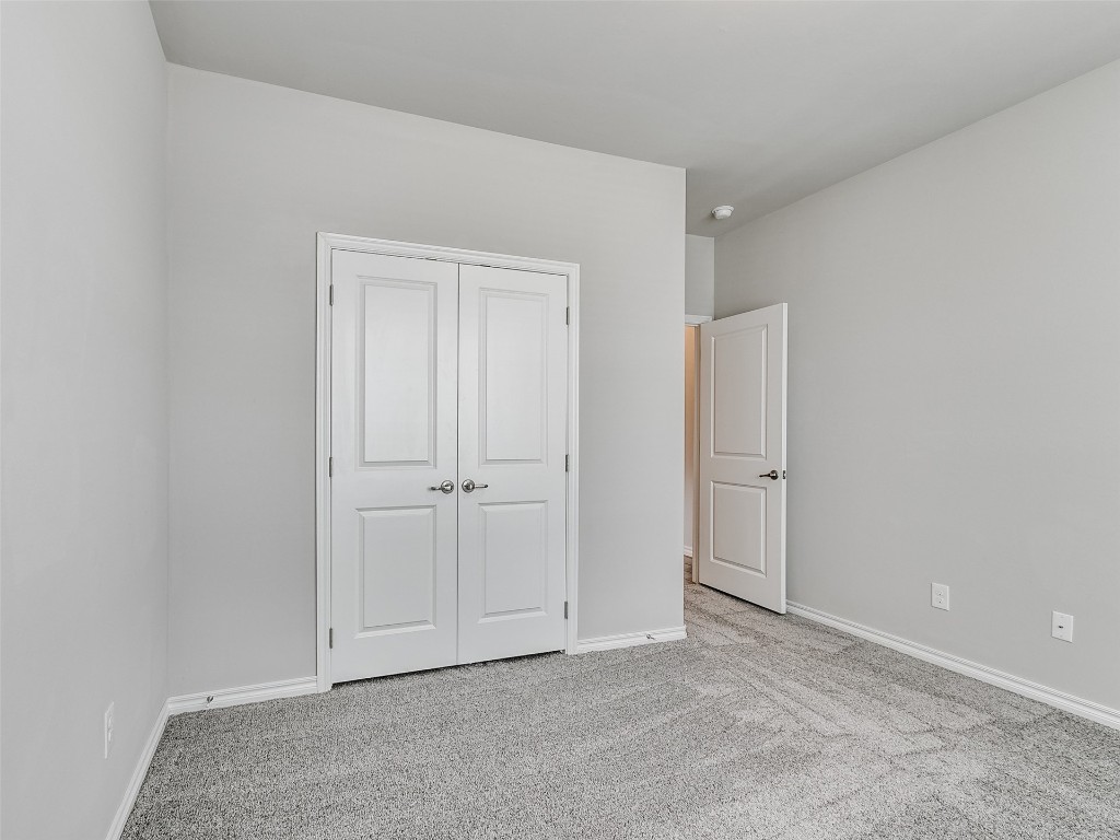 2508 Austin Glen Court, Yukon, OK 73099 unfurnished bedroom featuring light colored carpet and a closet