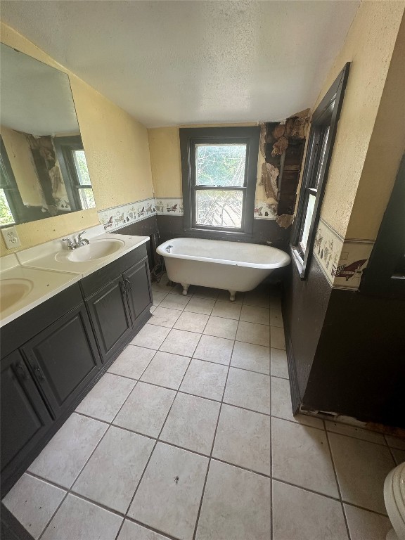 1304 NW 16th, Oklahoma City, OK 73106 bathroom with a bathing tub, dual vanity, tile floors, and a textured ceiling