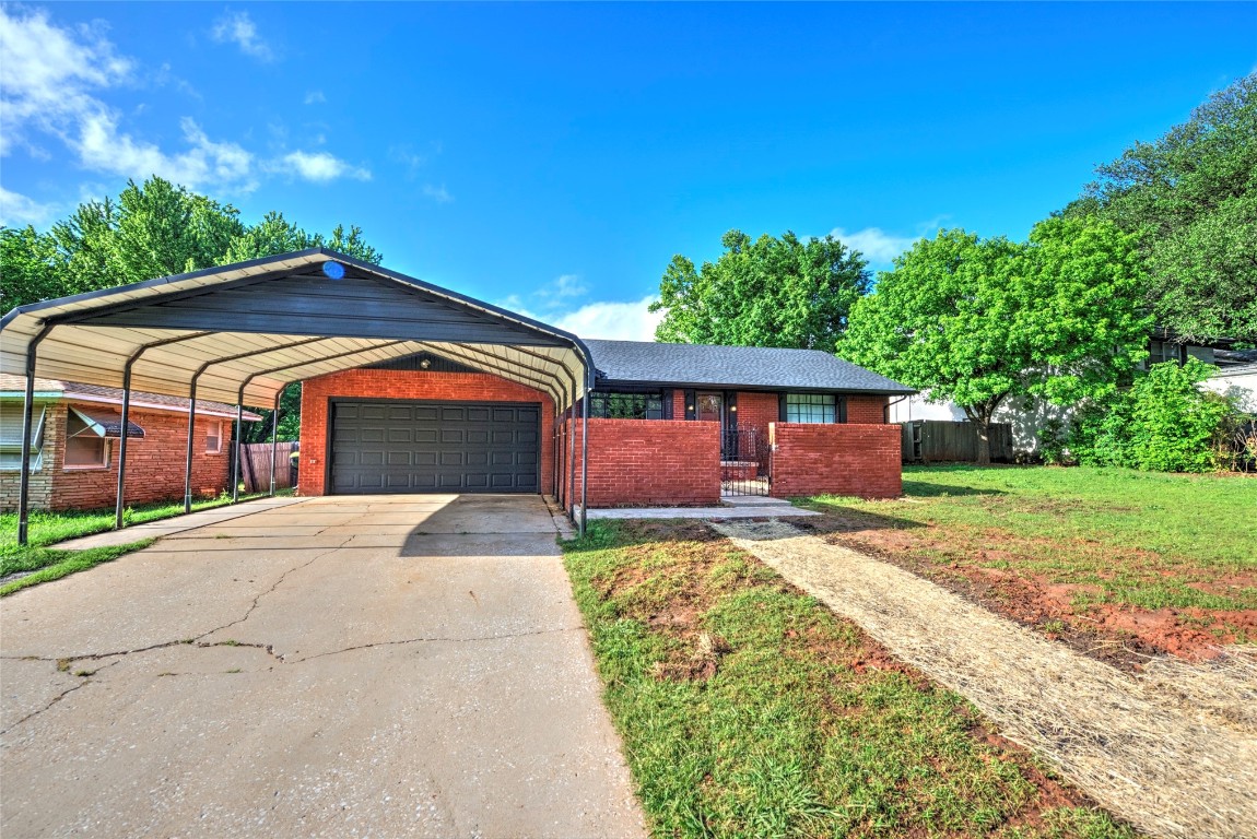 717 W Washington Street, Purcell, OK 73080 single story home with a carport, a garage, and a front lawn