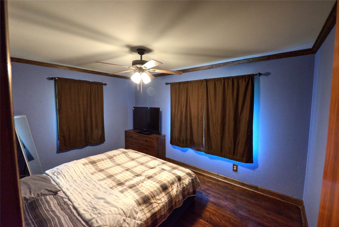 717 W Washington Street, Purcell, OK 73080 bedroom featuring ornamental molding, ceiling fan, and dark hardwood / wood-style floors