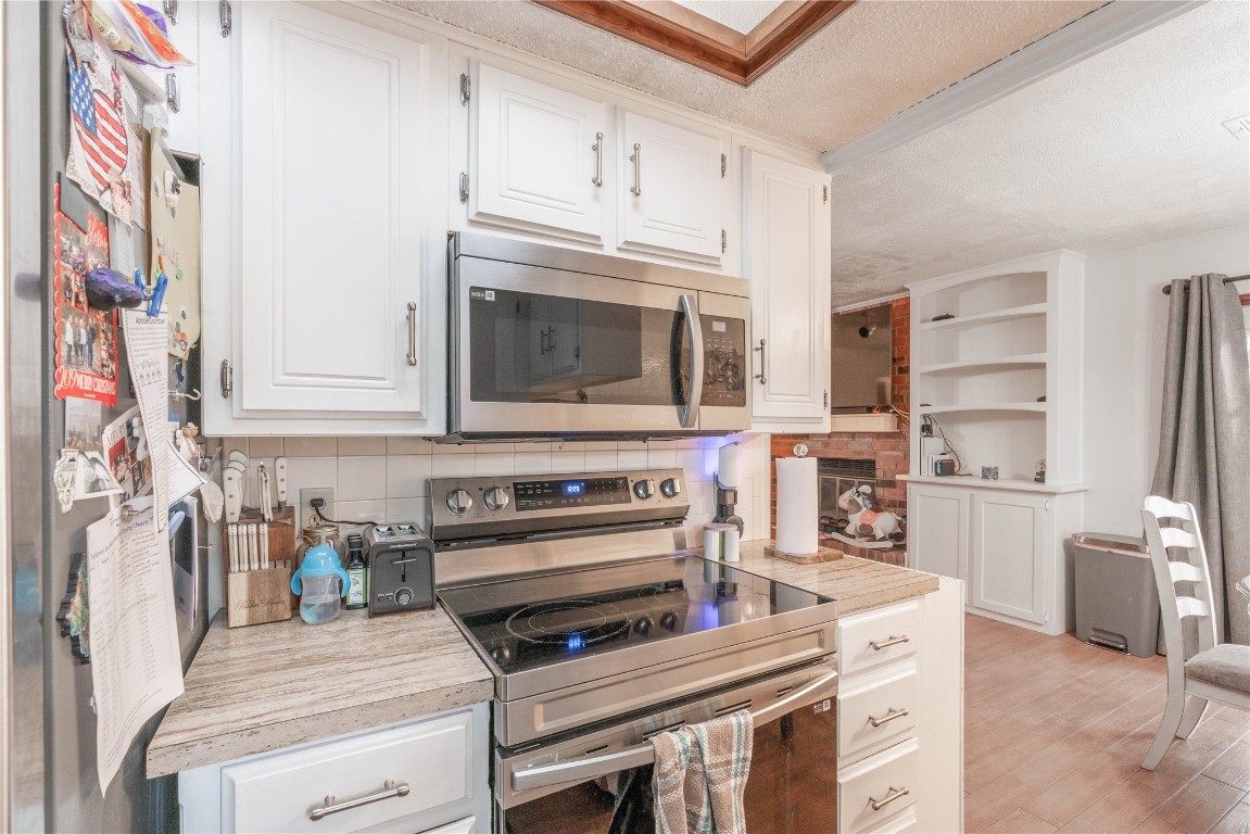 825 N Tiffany Court Way, Mustang, OK 73064 kitchen featuring white cabinets, tasteful backsplash, and dishwasher