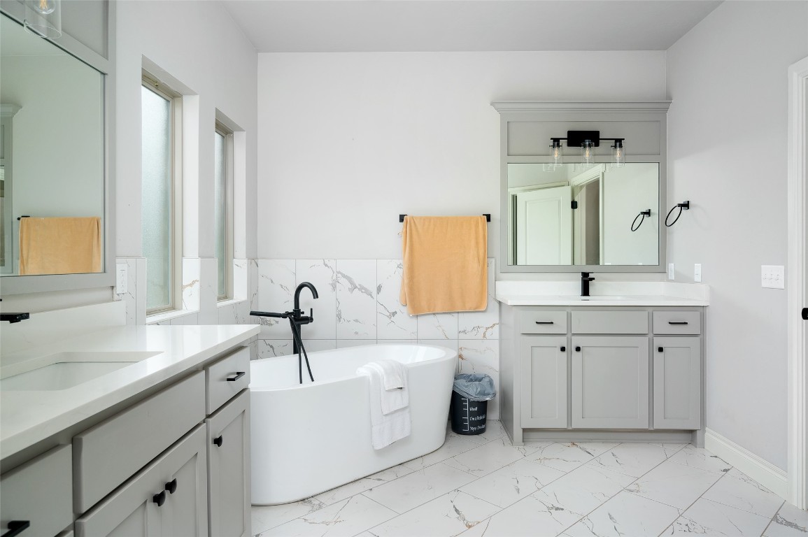 14709 Chambord Drive, Yukon, OK 73099 bathroom with double vanity, tile floors, a bathing tub, and tile walls