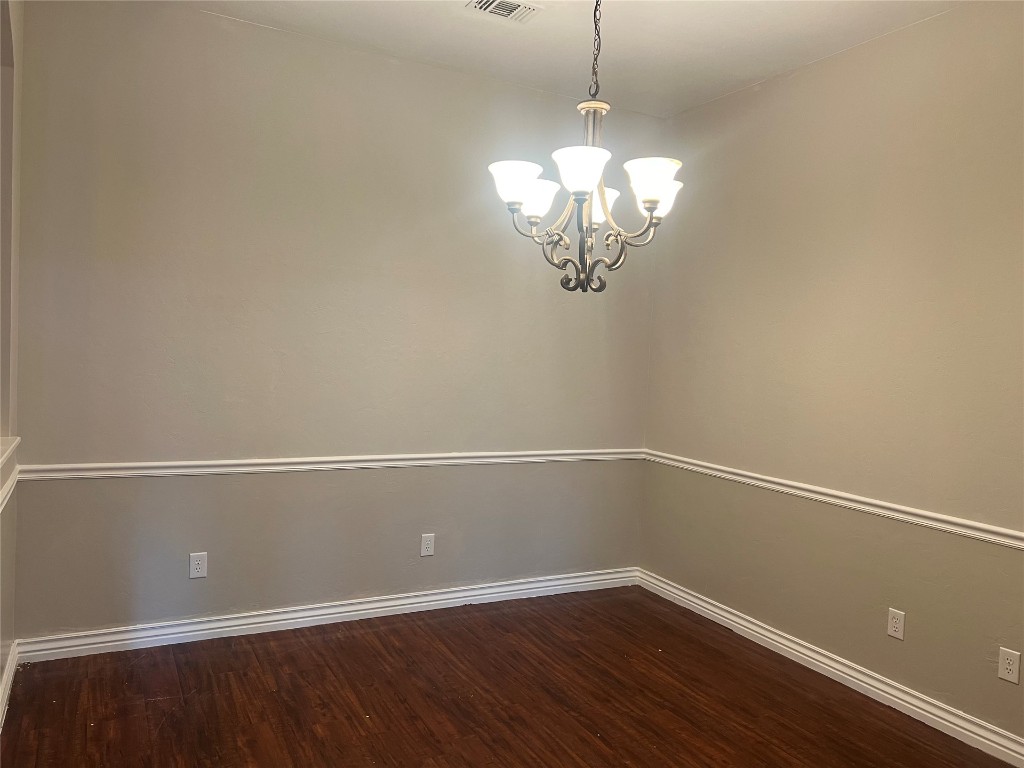 517 Hutton Road, Yukon, OK 73099 spare room featuring hardwood / wood-style floors and an inviting chandelier