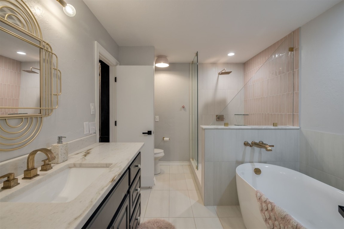 6001 Acorn Drive, Oklahoma City, OK 73151 bathroom featuring oversized vanity, toilet, tile floors, and a bath