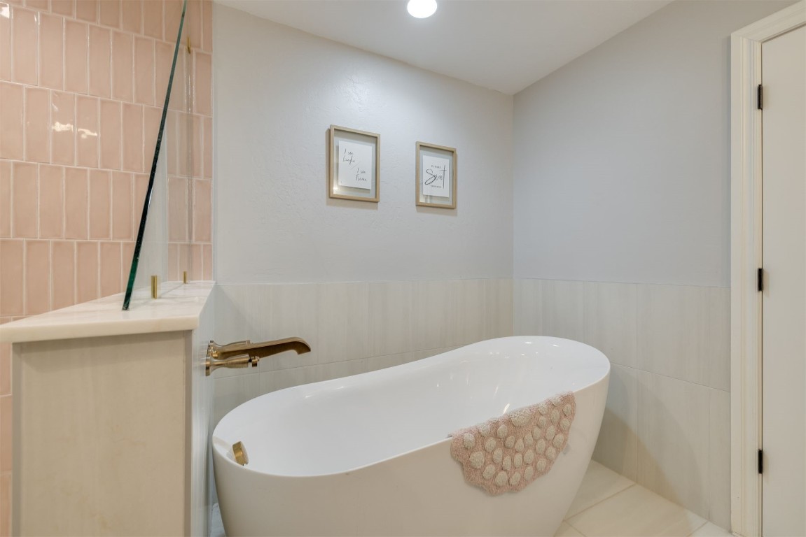 6001 Acorn Drive, Oklahoma City, OK 73151 bathroom with tile walls, tile flooring, and a bathtub