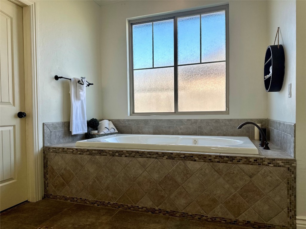 715 NW Elm Street, Piedmont, OK 73078 bathroom with dual bowl vanity, tile floors, a tile shower, and ornamental molding