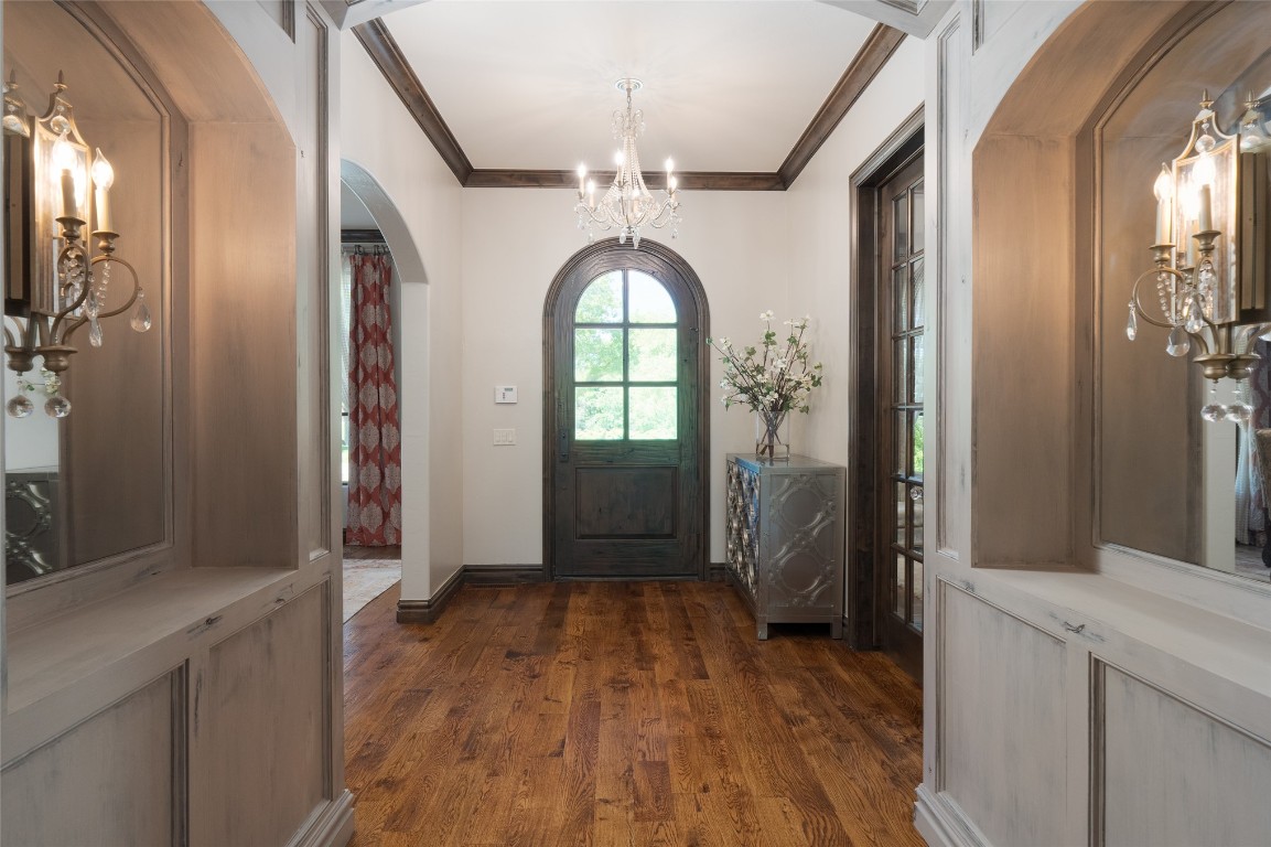 1200 Settlers Drive, Edmond, OK 73034 entryway featuring ornamental molding, dark hardwood / wood-style floors, and an inviting chandelier
