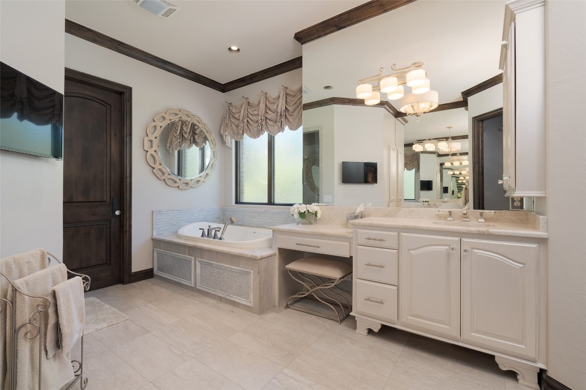 1200 Settlers Drive, Edmond, OK 73034 bathroom featuring crown molding, tile floors, vanity, a notable chandelier, and a relaxing tiled bath