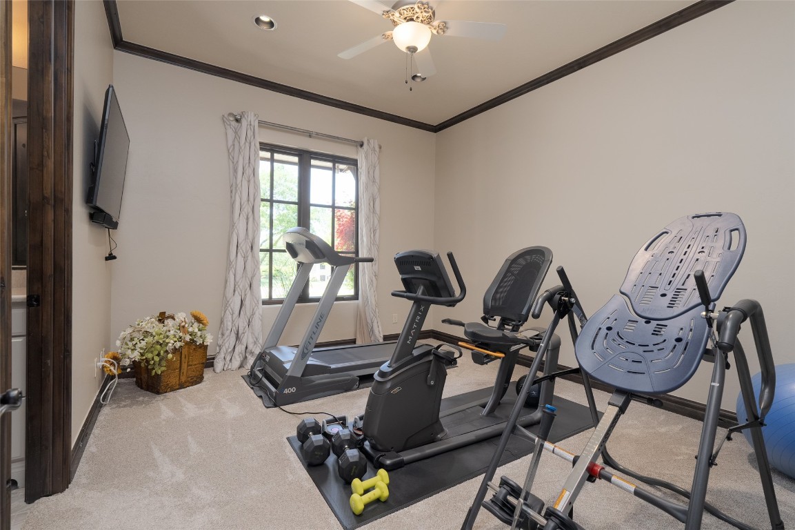 1200 Settlers Drive, Edmond, OK 73034 exercise room with ceiling fan, carpet, and crown molding
